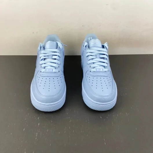Pair of light blue low-top sneakers standing on a grey floor