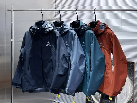 Four hooded jackets in dark blue, lighter blue, teal and rust on a rail; seller reference photo